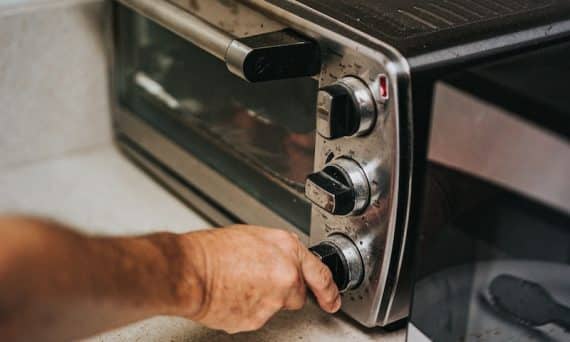 person holding stainless steel gas stove